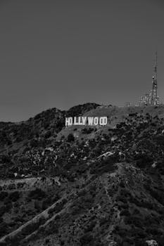 A black and white photo of the Hollywood sign located in the hills of Los Angeles, California.