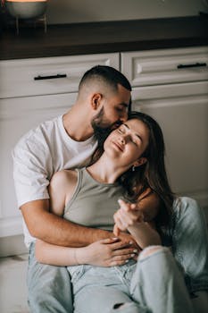 A loving couple enjoys a relaxing moment together in their kitchen, embracing and smiling.