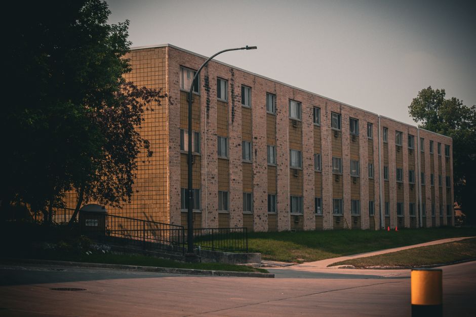 Exterior view of a residential building in urban setting with soft lighting and moody tones.