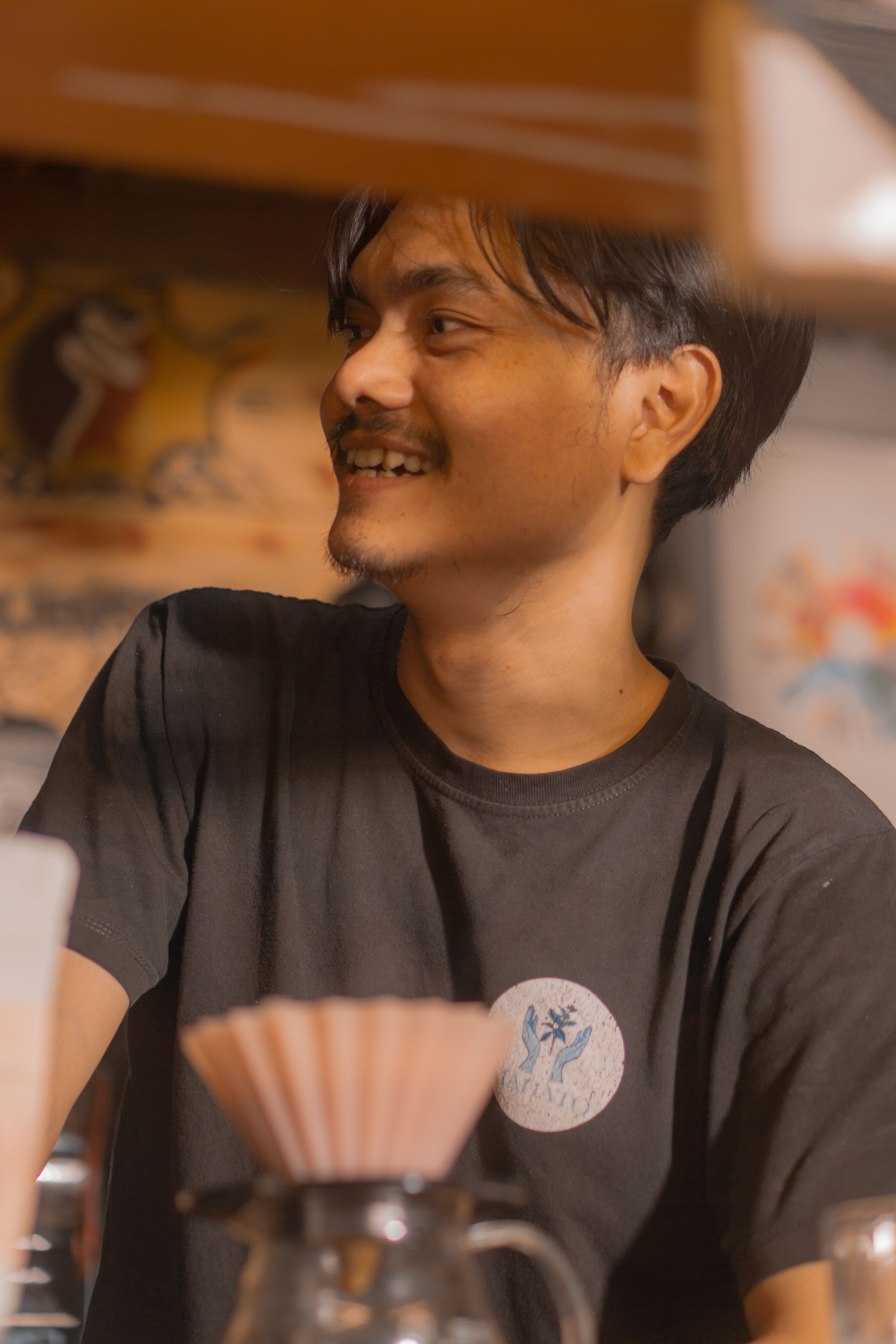 A joyful barista brews artisanal coffee in a cozy Indonesian café, highlighting local coffee culture. - Fotografer Sidoarjo
