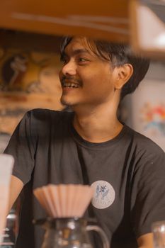 A joyful barista brews artisanal coffee in a cozy Indonesian café, highlighting local coffee culture. - Fotografer Sidoarjo