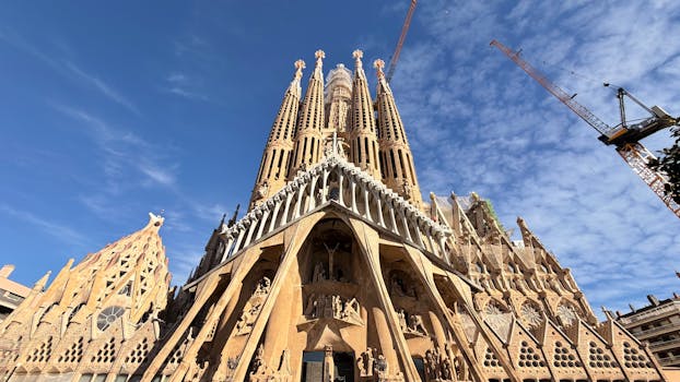 A stunning view of the iconic Sagrada Familia Cathedral in Barcelona, showcasing its intricate architecture against a clear blue sky.