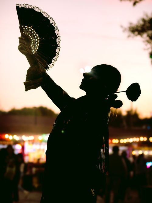 Free A captivating silhouette of a dancer holding a fan at sunset outdoors. Stock Photo
