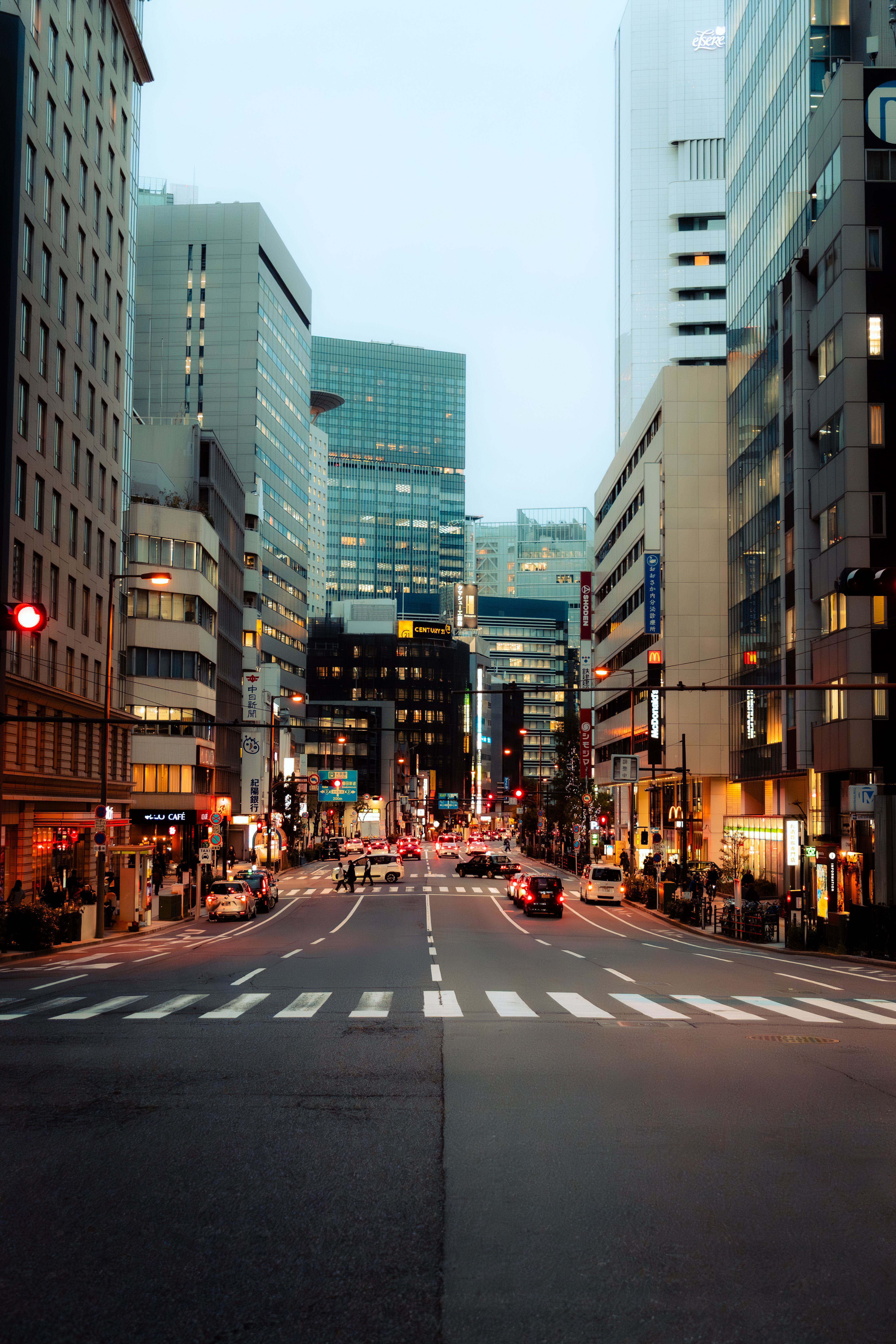 Bustling Tokyo street at dusk showcasing modern architecture and city life.