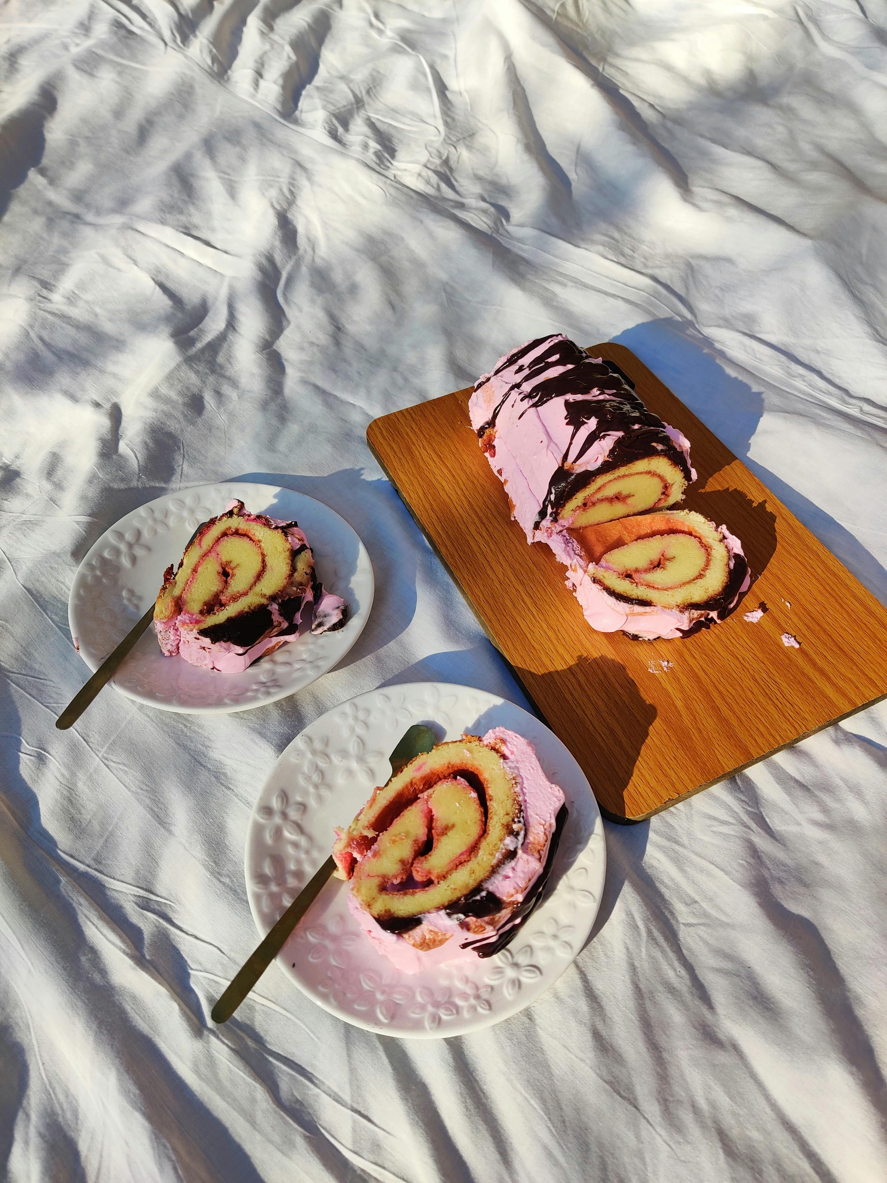 Gratis Un accattivante rotolo di torta svizzera rosa e cioccolato, perfetto per gli amanti dei dessert. Foto a disposizione