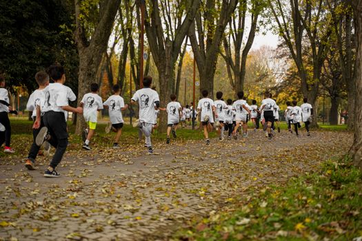 A group of kids participating in a running event in a leafy park in Bursa, Türkiye.