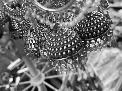 Close-up of detailed traditional jhumka earrings in monochrome.
