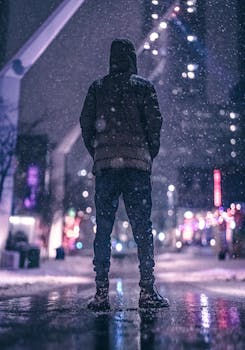 在蒙特利尔一条白雪皑皑的街道上，一个人站在寒冷的冬夜里