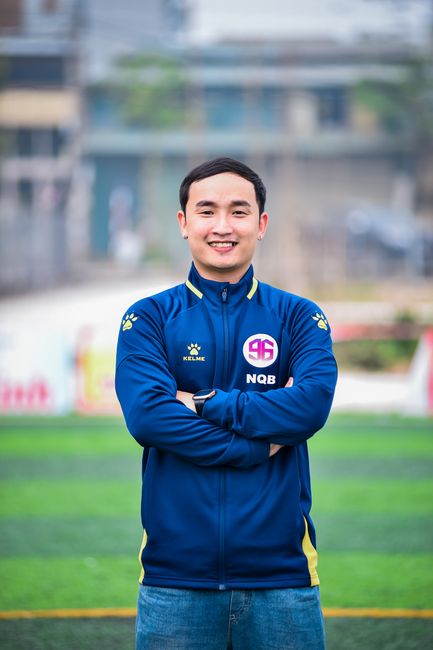 Portrait of a smiling man standing on an artificial turf in Hà Nội.