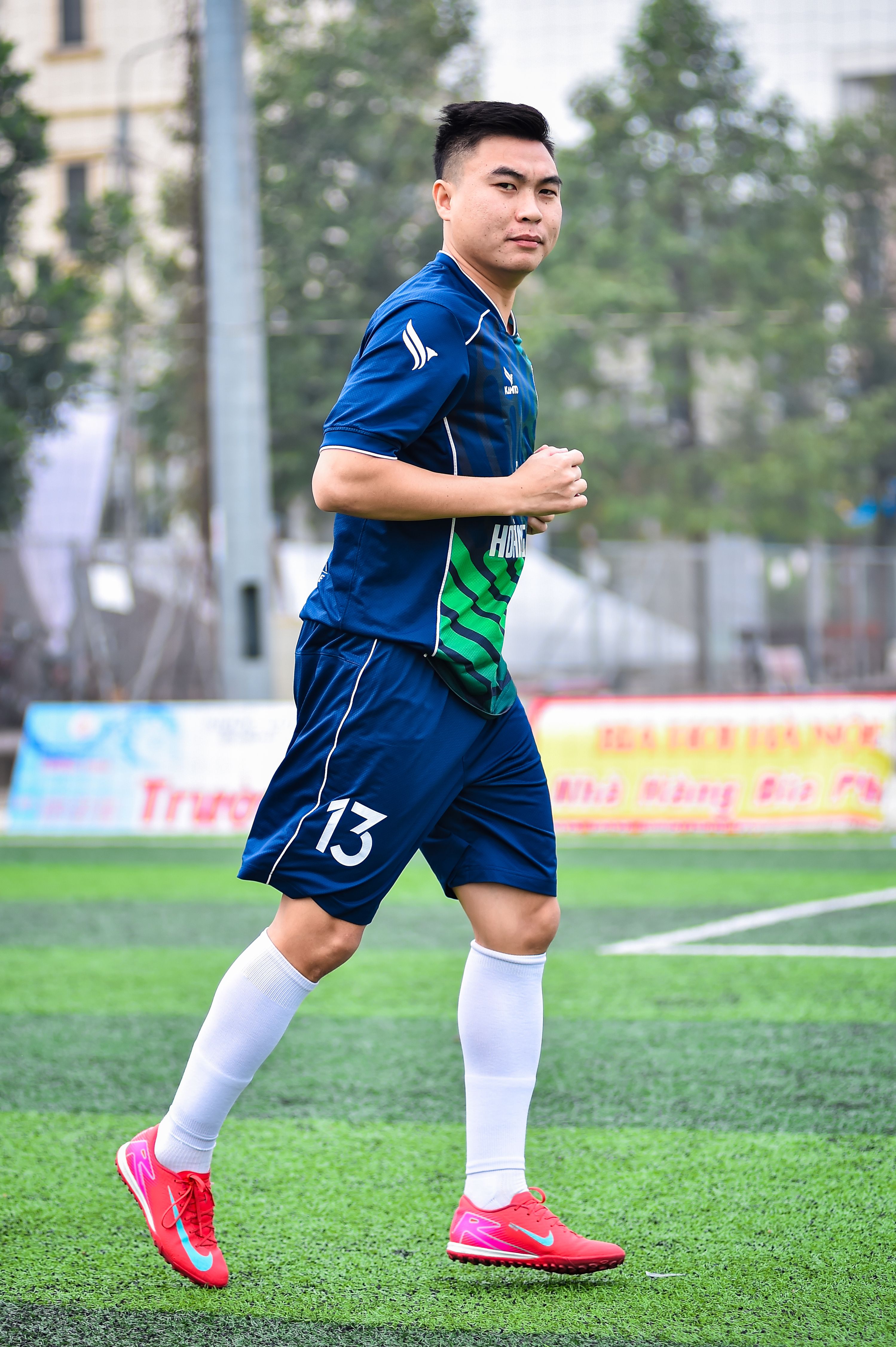 Football player on artificial turf soccer field in Hanoi, Vietnam.
