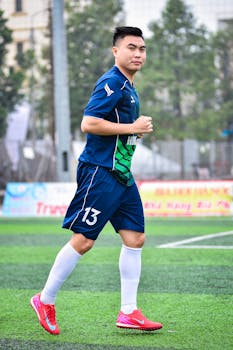 Football player on artificial turf soccer field in Hanoi, Vietnam.