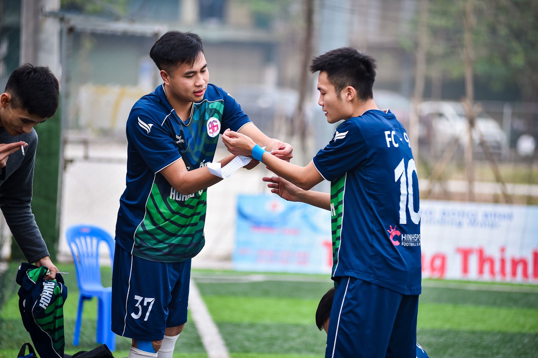Young football players prepare for a game on a field in Hà Nội, Việt Nam.