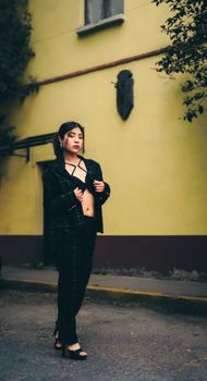 A confident woman poses in a stylish plaid suit outdoors. Urban fashion and style captured in natural lighting.