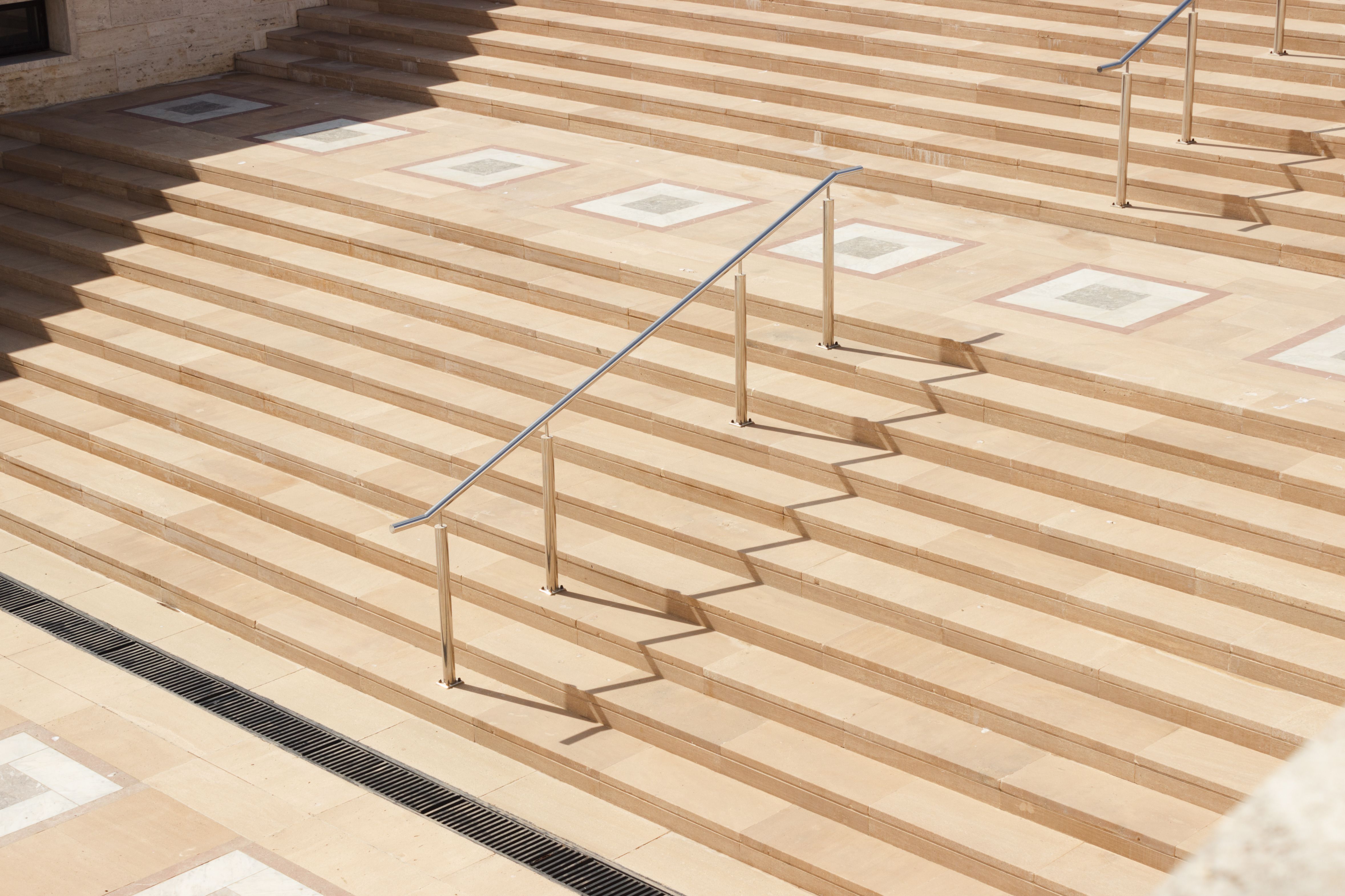 Sunny day view of modern architectural steps casting shadows.
