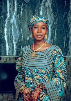 Portrait of an African woman in vibrant traditional clothing and jewelry, exuding grace and elegance.