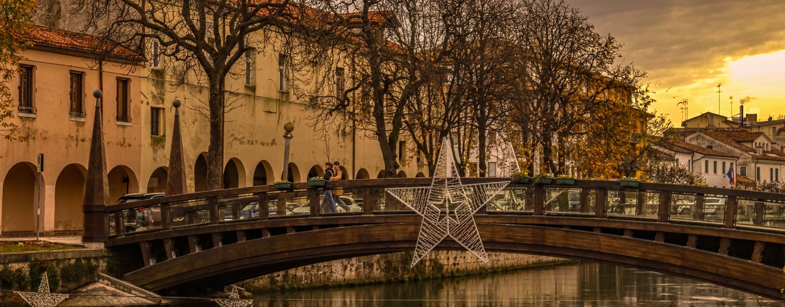 Charming view of a historical bridge adorned with stars during winter sunset.