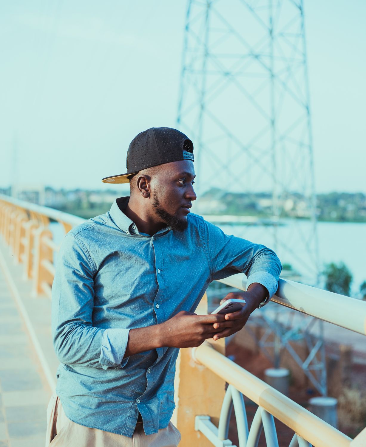 Casual Young Man on Urban Bridge with Smartphone · Free Stock Photo