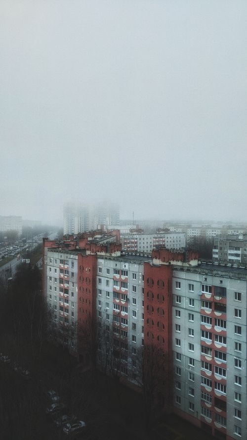 Free An atmospheric cityscape of Minsk under a foggy sky, showcasing rows of high-rise buildings in soft light. Stock Photo