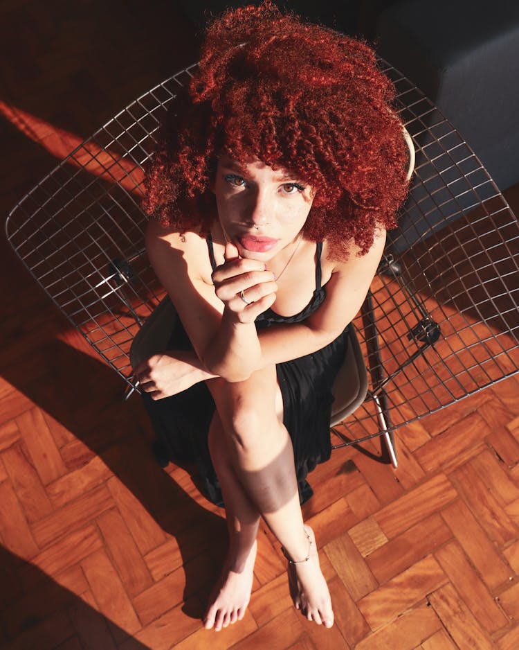 Overhead Photo Of Woman In Black Outfit Sitting On Chair Posing While Looking Up