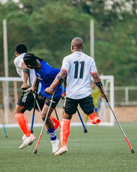 Dynamic image of athletes in an adaptive soccer match using crutches, highlighting inclusivity and skill.
