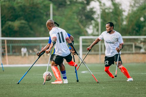 Free Dynamic scene of amputee soccer players competing intensely on the field. Stock Photo