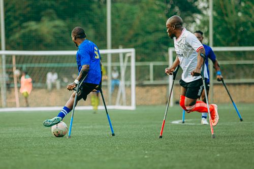 Free Exciting match of amputee football players showcasing their skills on a green field. Stock Photo