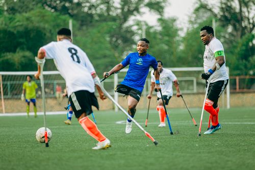 Free Energetic amputee football game showcasing athletes' skill and determination on a green turf field. Stock Photo