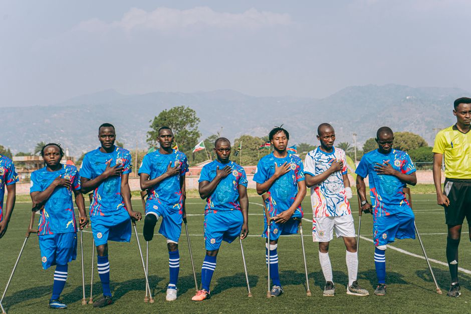 Amputee soccer team standing in unity on a sunny day on the sports field.