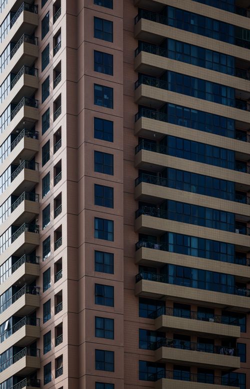 Free Close-up of a modern high-rise building showcasing architectural design with glass and balconies. Stock Photo