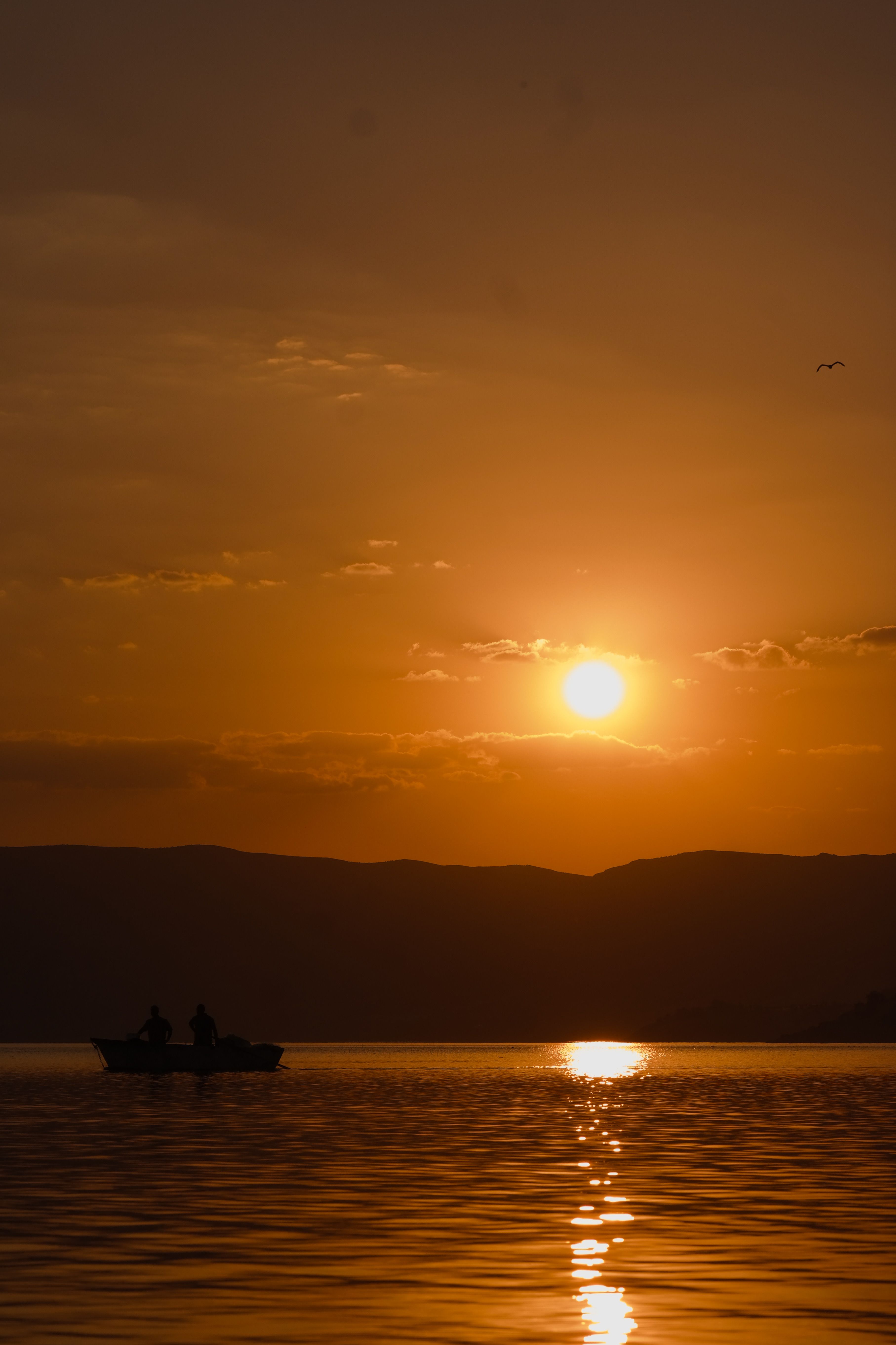 Serene Sunset Boat Ride on Tranquil Lake · Free Stock Photo