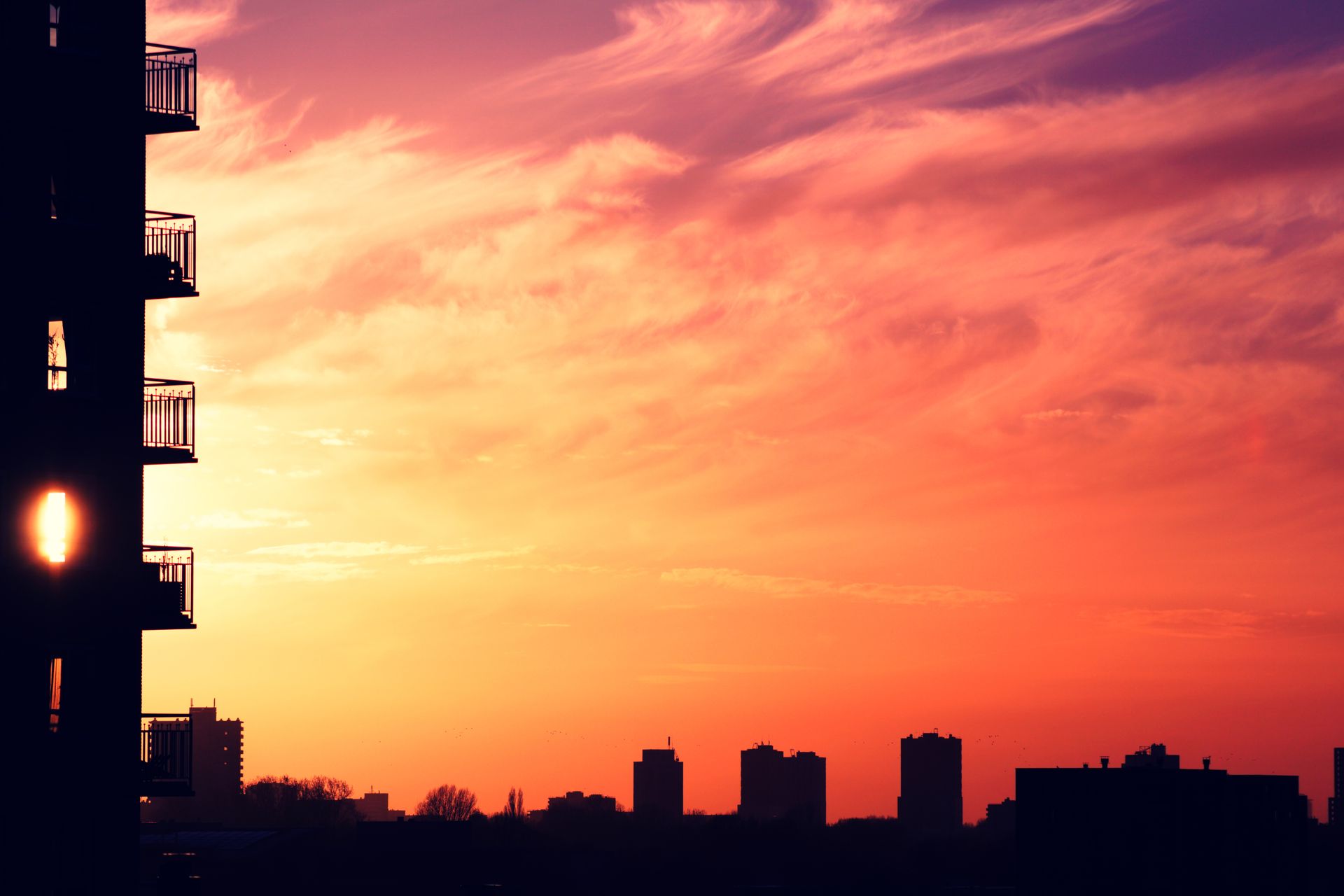 Silhouetted cityscape at sunrise featuring vibrant colors and striking architecture.