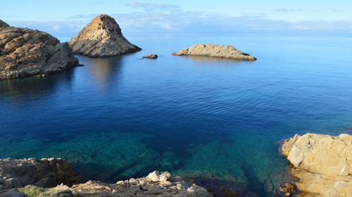 Free Serene coastal landscape of L'Île-Rousse, Corsica with rocky formations and clear blue waters. Stock Photo
