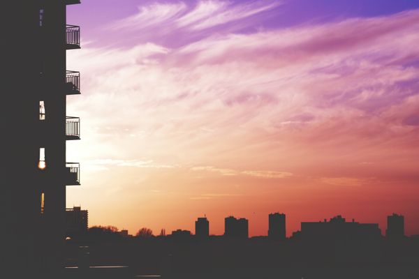 Captura de um deslumbrante horizonte urbano ao pôr do sol, exibindo edifícios silhuetados contra um céu colorido.