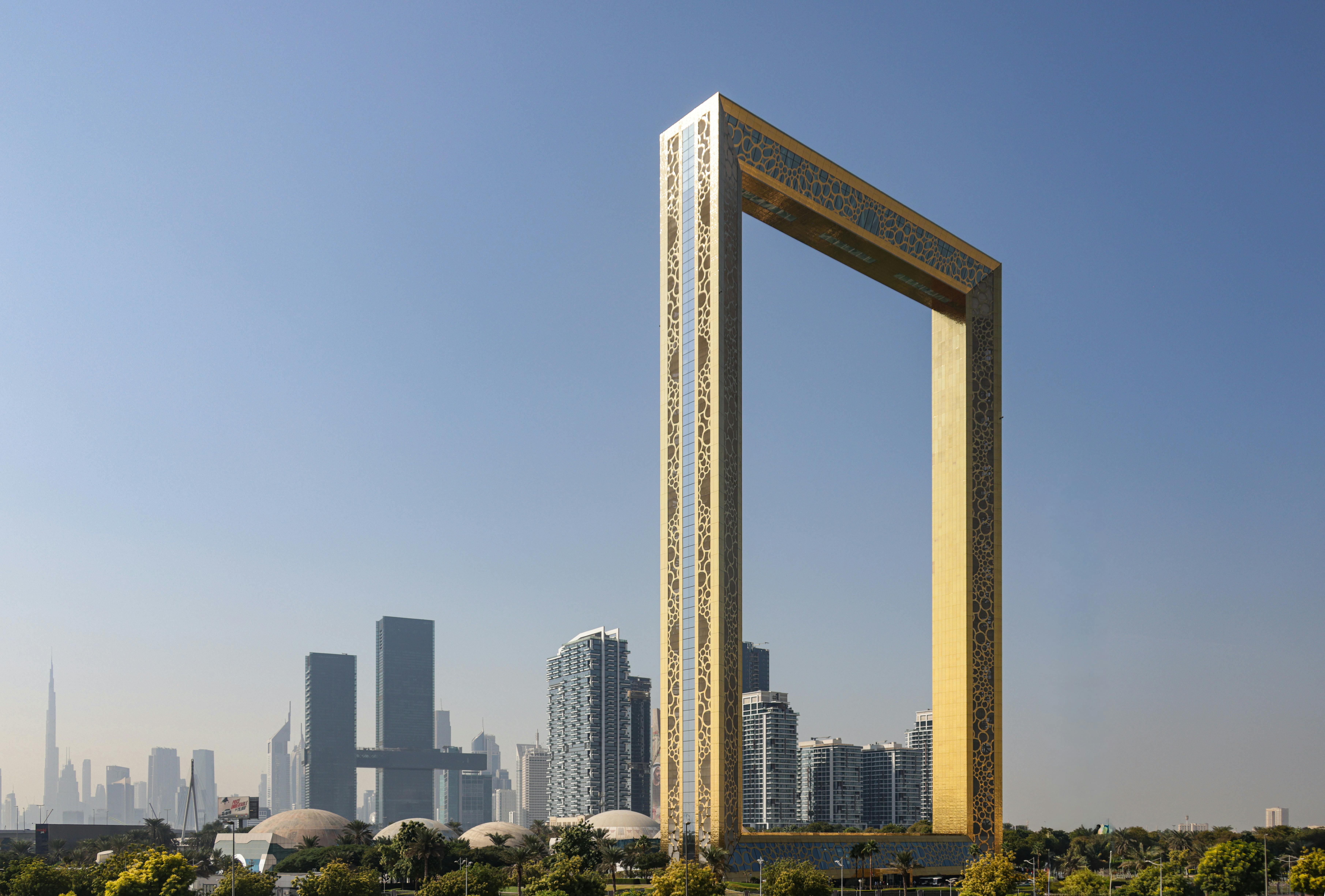 Dubai skyline with the Dubai Frame in the foreground at sunset, representing modern growth and community life in the UAE – UAEThrive.