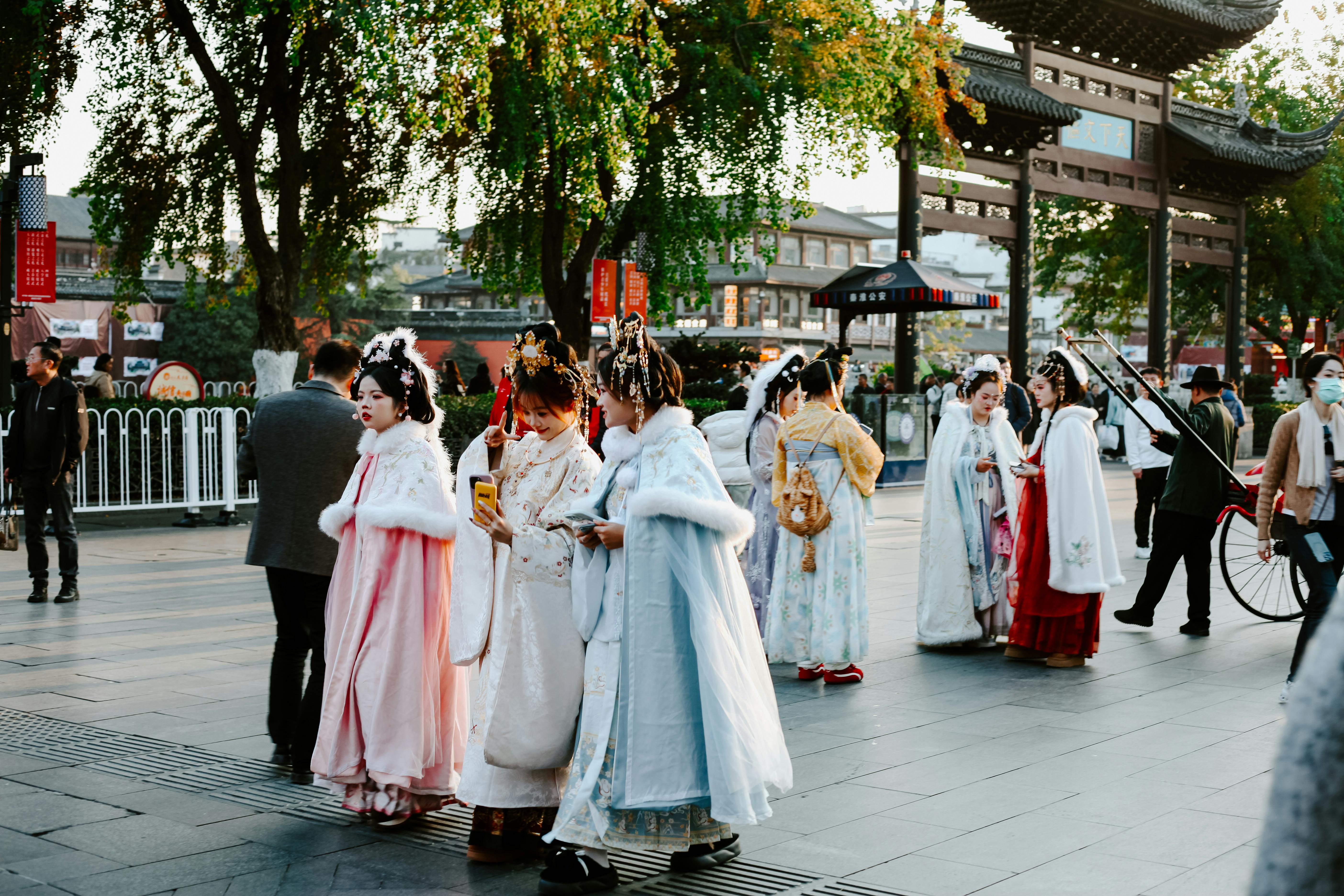 People in Nanjing wear Hanfu, showcasing Chinese culture and fashion on a lively street.