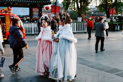 Free People in traditional attire stroll through a vibrant Nanjing street in autumn. Stock Photo