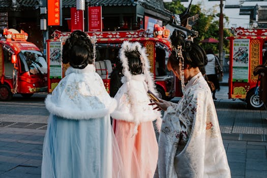Donne in abiti tradizionali cinesi camminano lungo una vivace strada di Nanchino decorata con colori vivaci.