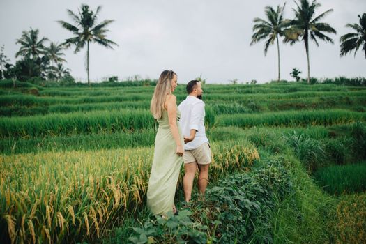 A couple enjoying the lush greenery of Bali's famous rice terraces. Perfect for travel and lifestyle imagery.