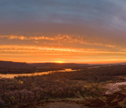 A breathtaking sunset over the Mississippi River near Kellogg, Minnesota, showcasing vibrant skies and lush landscapes.