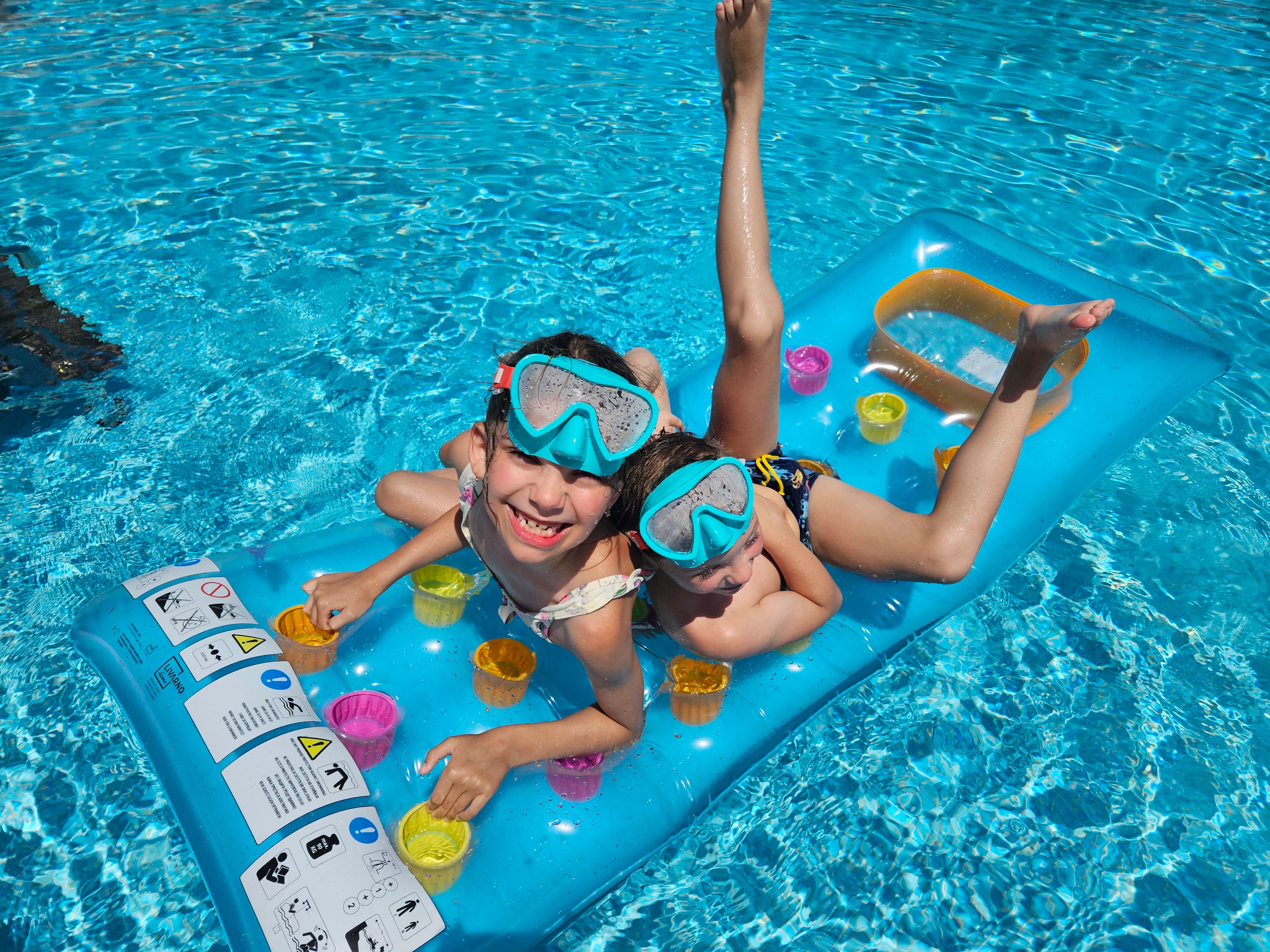 Two Kids Enjoying Summer Fun on Pool Float · Free Stock Photo