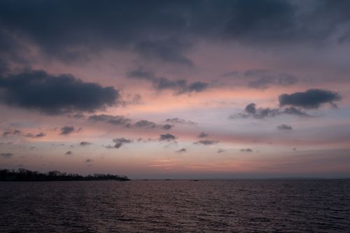 Free Beautiful sunrise over the ocean with a pink and purple sky, creating a tranquil and serene atmosphere. Stock Photo