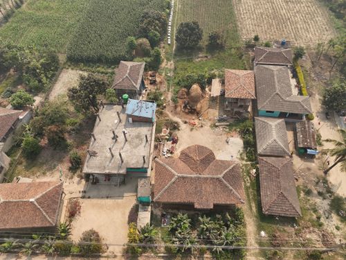 Free Aerial shot of traditional houses and farmland in a rural Nepalese village. Stock Photo