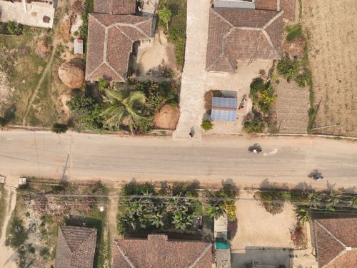 Free Aerial photograph capturing a rural village with traditional houses, roads, and vegetation in South Asia. Stock Photo