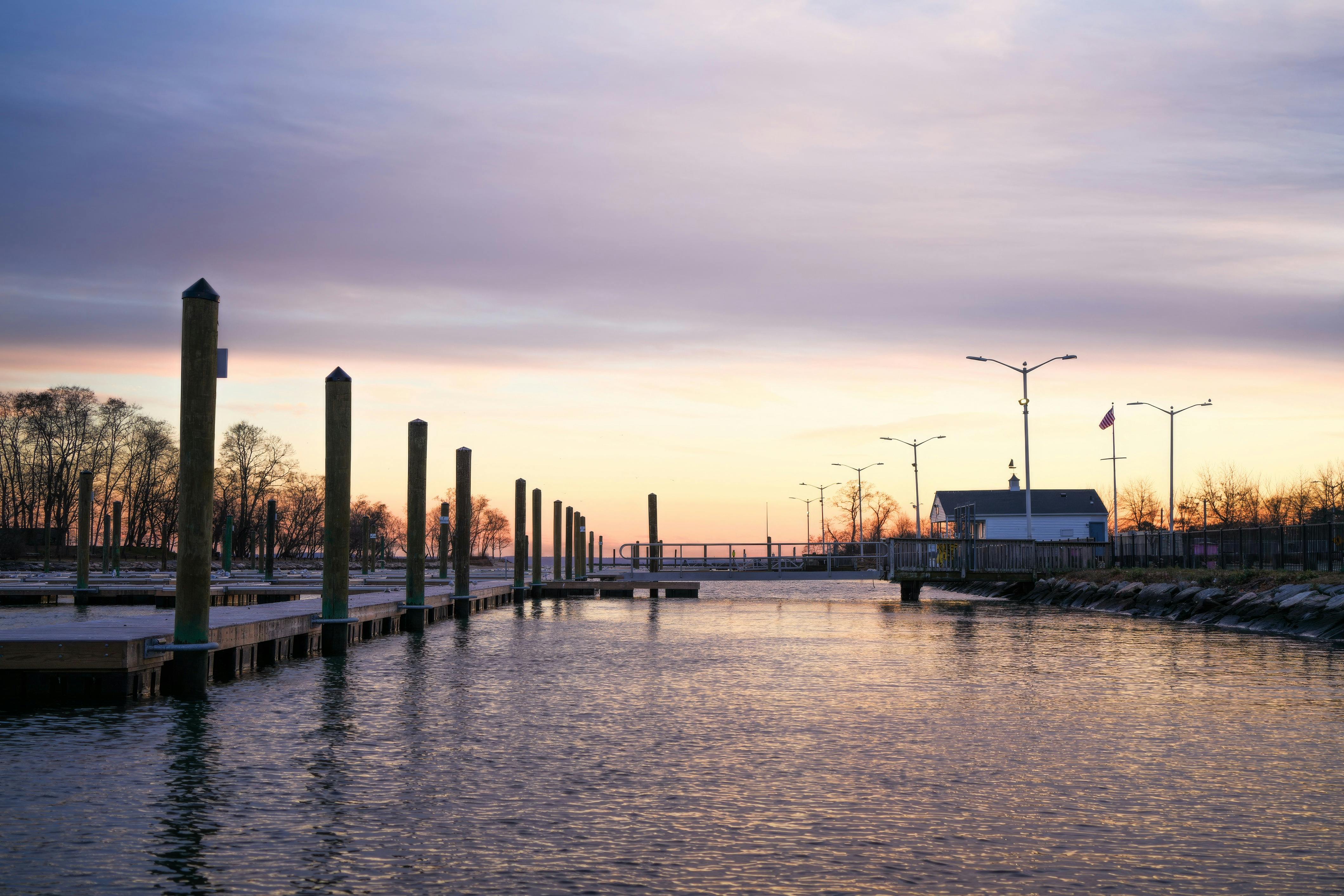Peaceful waterfront scene with empty docks at sunset, calm water and vibrant sky.