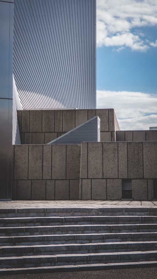 Free Explore the striking geometric patterns of contemporary architecture under a clear blue sky. Stock Photo