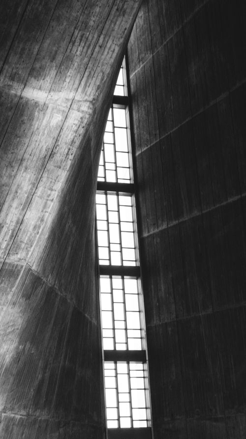 Free Black and white abstract architecture with curved walls and grid windows. Stock Photo