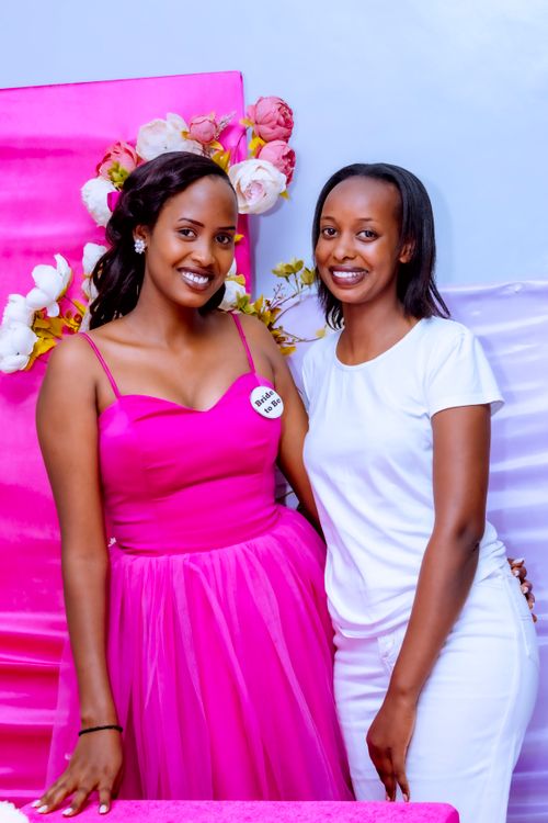 Free Two women posing in elegant pink and white attire at a festive event. Stock Photo