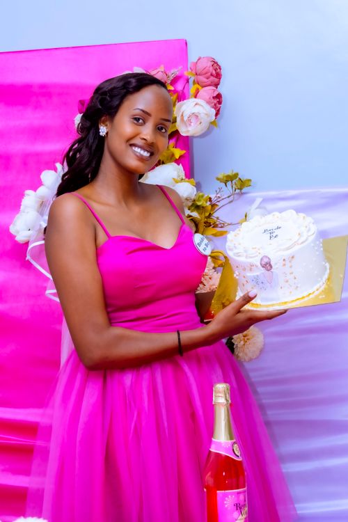 Free Woman in pink dress holding a decorative cake at a celebration. Stock Photo