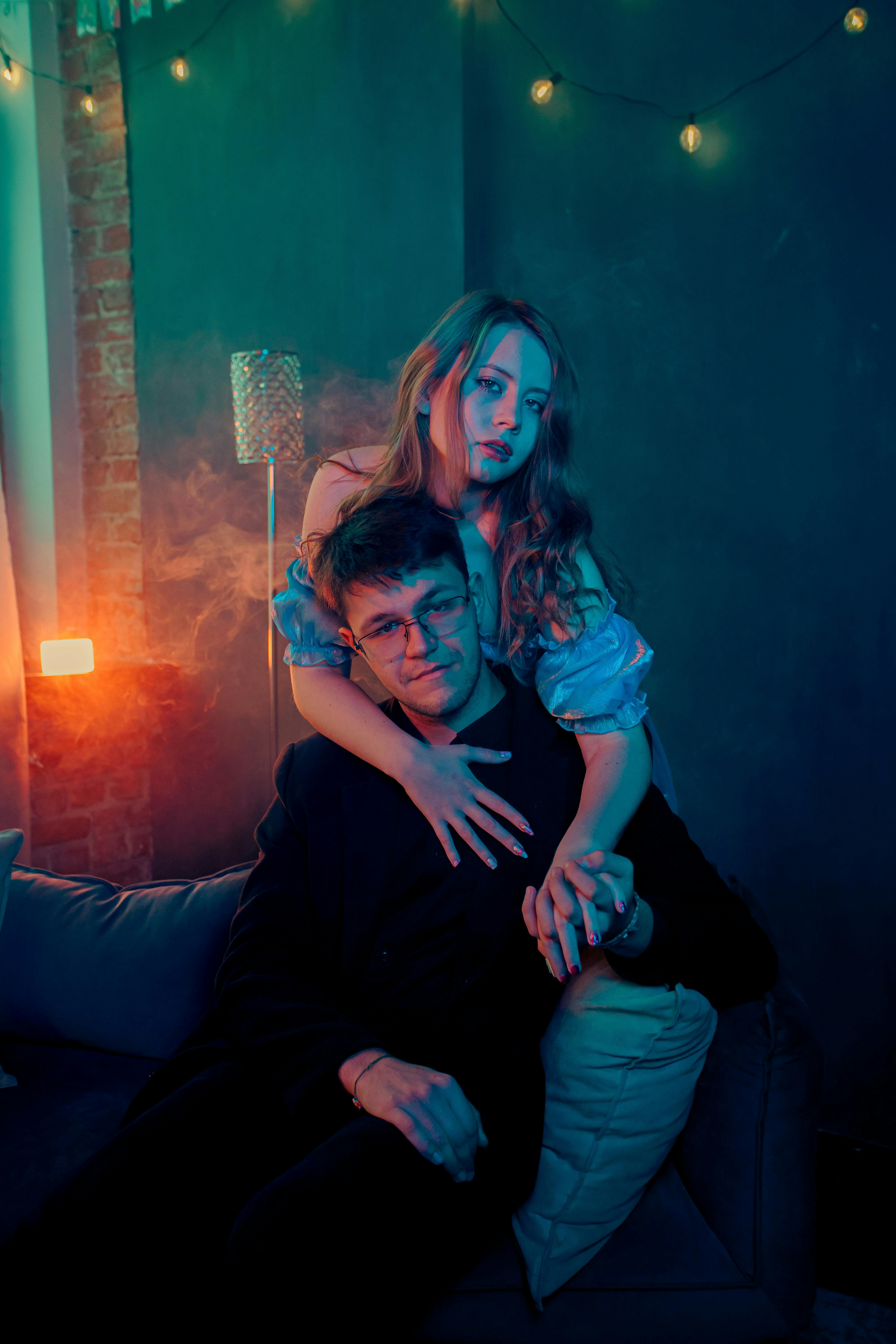 Romantic couple in dimly lit modern room, close intimate connection illustrating guided desire in peaceful haze