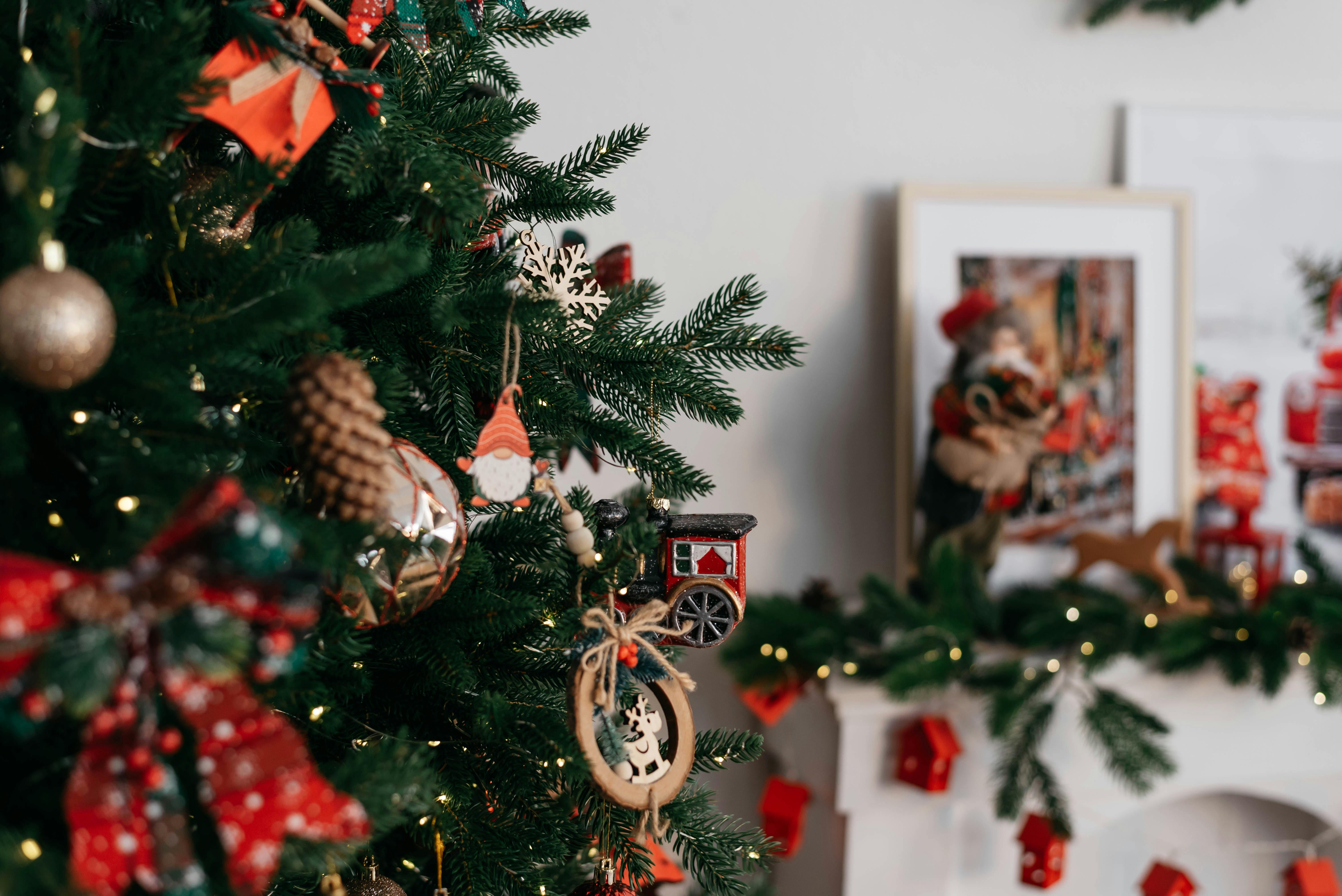 Christmas tree with ornaments and fireplace decorations creating a cozy festive atmosphere.